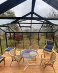 Vue intérieure d'une serre en verre Hélène de la marque ACD 15.79 m2 - Orangerie avec des mobiliers de jardin à l'intérieur