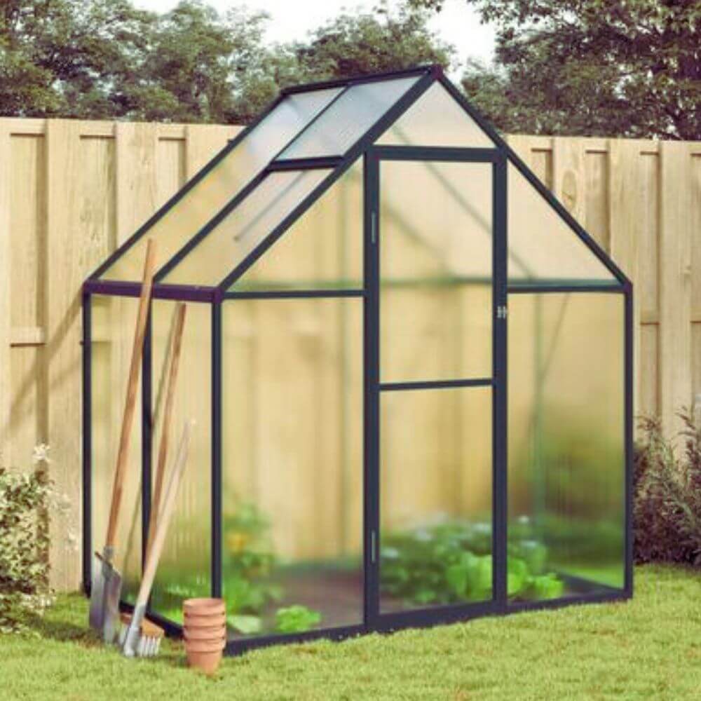 Mini serre de jardin fabriquée en polycarbonate dans un jardin